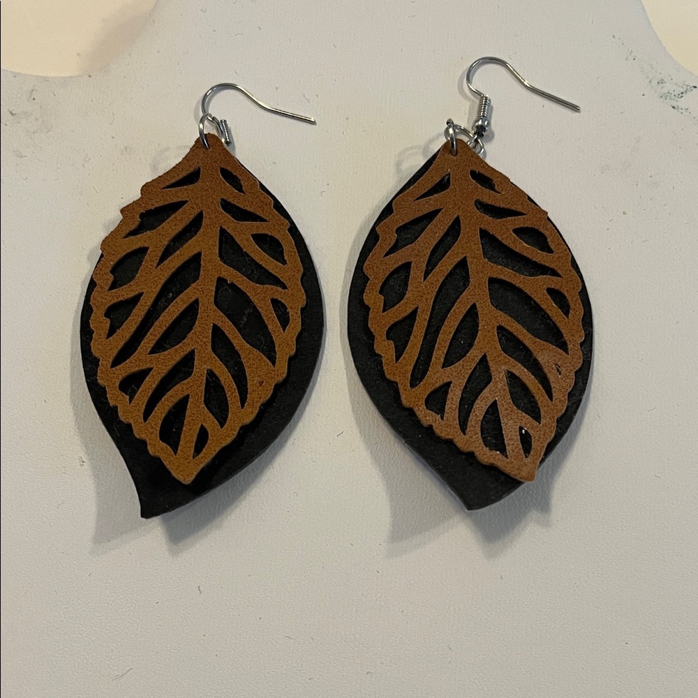 Laser cut leather leaf design on black suede background.
